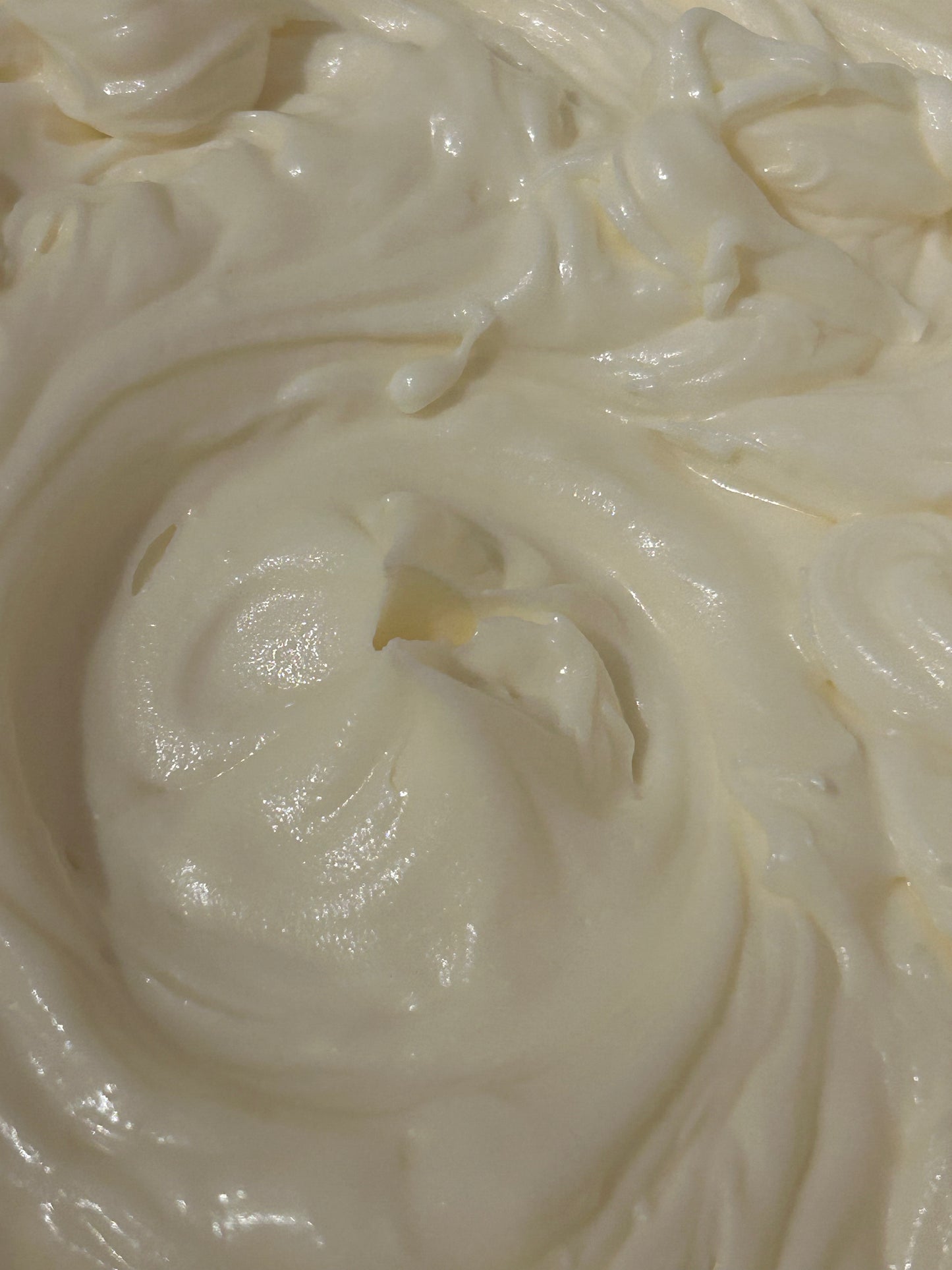 Close-up of creamy white whipped body butter with a swirl pattern